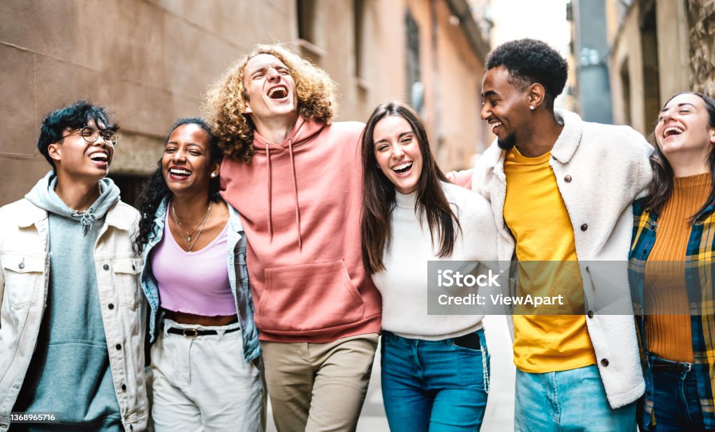 Life style concept with milenial friends walking together at old town center - Happy guys and girls having fun around Barcelona streets - University students on travel vacations  - Bright vivid filter Teenager Stock Photo