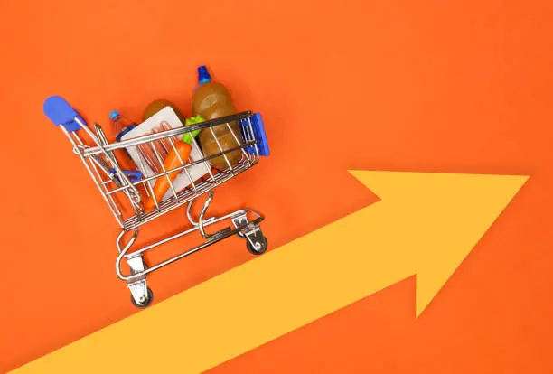 Photo of Shopping cart with groceries over an arrow