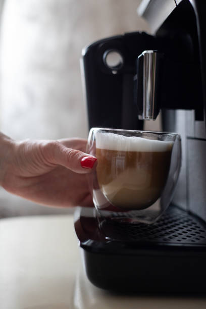 istock A woman's hand takes a transparent cup of coffee from a coffee machine 1368967331