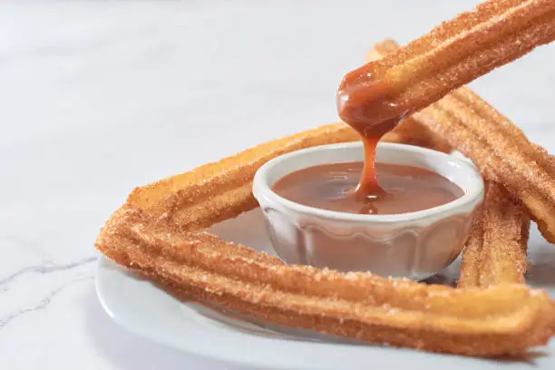 Mexican churros served on a homemade plate.