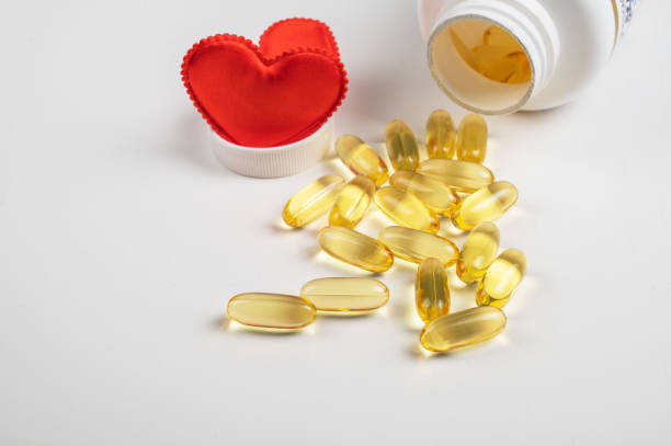 istock Gold fish oil isolated on white background with red hearts 1368968743