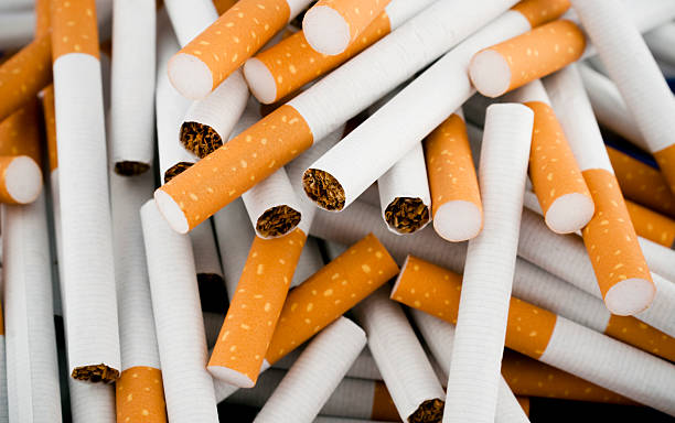 Cigarettes randomly piled in a large heap stock photo