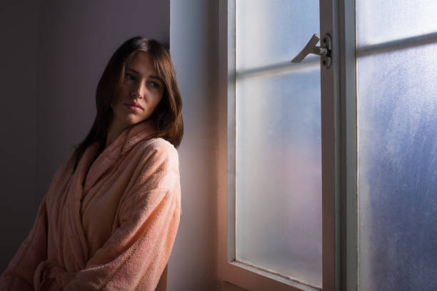 istock Woman in bathrobe in front of the window 1368972694