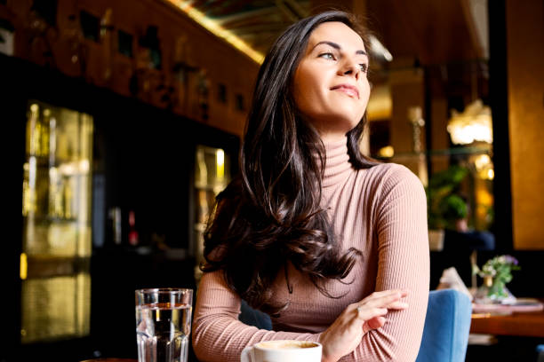 istock Young woman drinking coffee at the cafe 1368972849