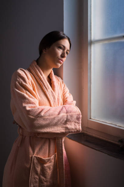 istock Woman in bathrobe in front of the window 1368973009