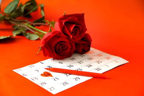 istock Three red roses and a calendar with the date. 1368974250