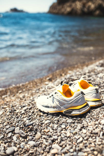 istock White sports sneakers on the beach 1368975349