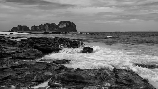 Seasscape of motion wave hit stone arch at Bamboo island or Koh Mai Phai, Krabi, Thailand. Famous travel destination or summer holiday maker of Siam. Black and white color process.