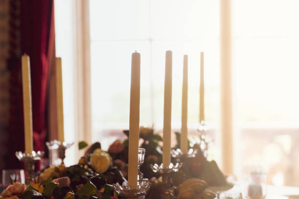 istock Table decoration with candles and a window in the background with a cozy sun. 1368978826