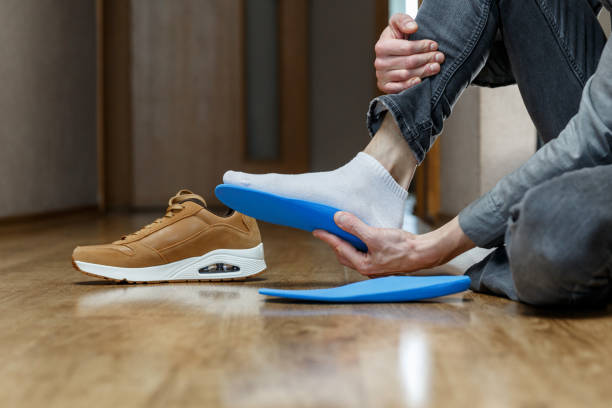istock Man putting new custom insole in a shoe. 1368980476