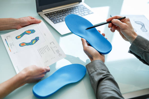 doctor consulting patient on custom orthotic insoles in a clinic for a personalised custom fit. - plattfot bildbanksfoton och bilder