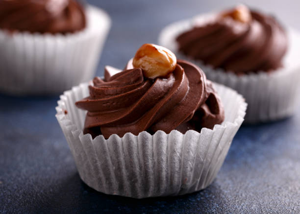istock Meringue, pavlova chocolate cupcakes with cream and nuts 1368980642