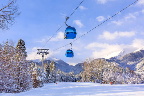 Bansko, Bulgaria winter ski resort panorama with gondola lift cabins, Pirin mountain peaks view and slope