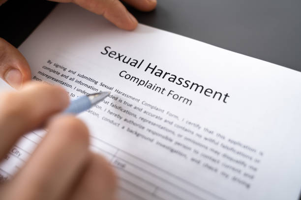 istock Human Hand Filling Sexual Harassment Complaint Form With Pen 1368983649