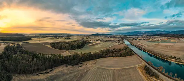 colorful morning mood with partial clouds with a view over the aare river, fields and forest sections. On the outskirts of the city of Biel Bienne, canton Bern, Switzerland