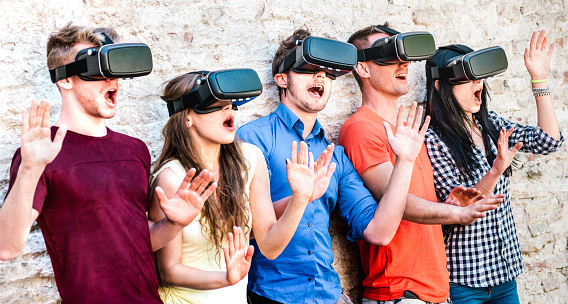 Amigos sorprendidos explorando el metaverso en gafas de realidad virtual - Realidad virtual y concepto de tecnología portátil con personas felices divirtiéndose junto con gafas de auriculares - Tendencias de generación digital en filtro brillante photo