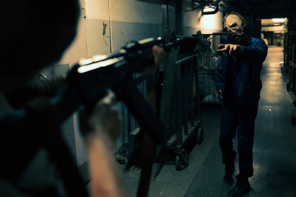Close up of fighter pointing gun at zombie in dark hallway, post apocalyptic setting, copy space
