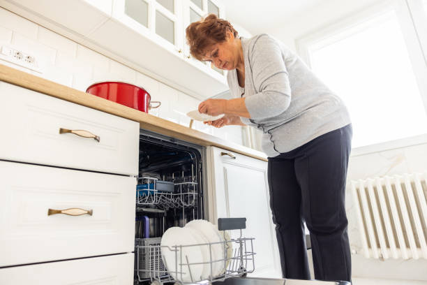 istock Senior woman loads dishwasher 1368986559