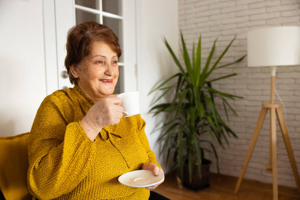 istock Senior woman drinking coffee at home 1368988264