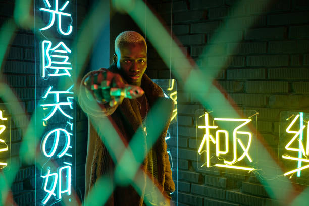 istock Cyberpunk man with gun standing in darkness 1368989375