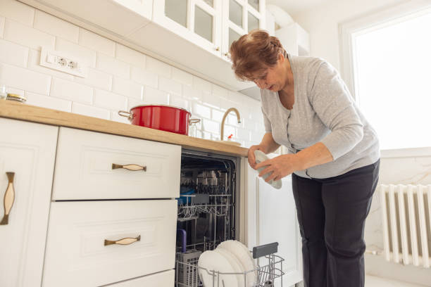 istock Senior woman loads dishwasher 1368989412