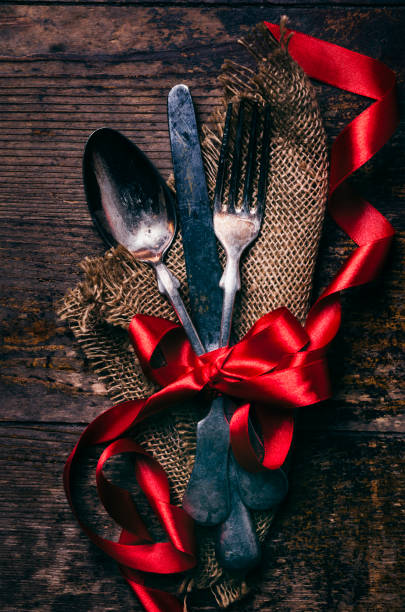 Valentine day dine. Valentines dinner background with vintage silverware and red ribbon on wooden table. Luxury restaurant menu for romantic celebration event.