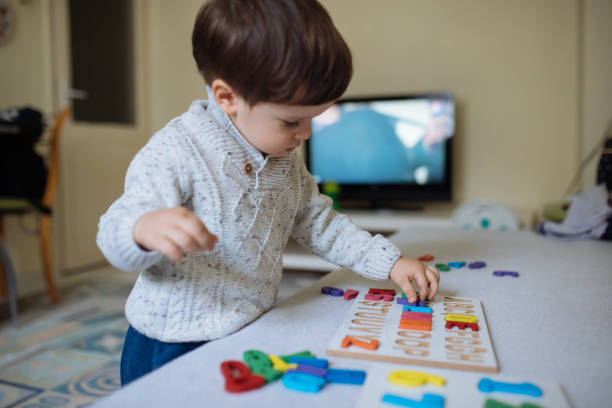 istock Cutle little boy playing with wooden alphabet puzzle 1368990960