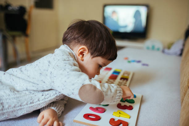 istock Cute little boy making wooden number puzzle 1368991016