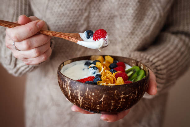 istock Woman eating healthy breakfast from coconut bowl 1368991481