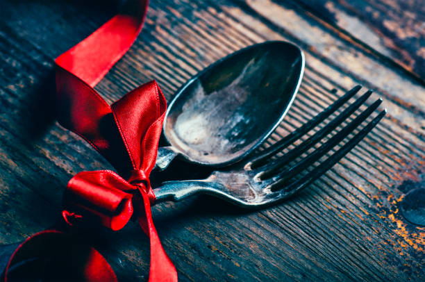 istock Valentines dinner background with vintage silverware and red ribbon on wooden table. Luxury restaurant menu for romantic celebration event. Valentine day dine. 1368991502