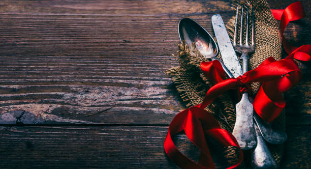 istock Valentines dinner background with vintage silverware and red ribbon on wooden table. Luxury restaurant menu for romantic celebration event. Valentine day dine. 1368991503