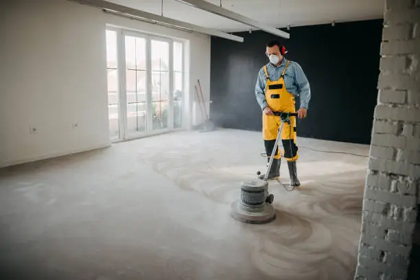 Man with a special machine polishes the floor