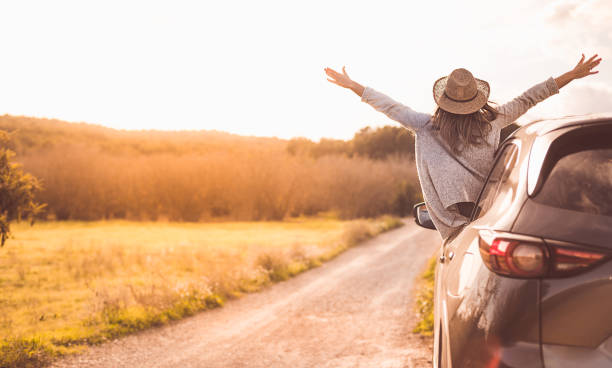 Happy girl celebrating success at sunset. The girl is wearing a hat and her arms are outstretched. Happy girl celebrating success at sunset. The girl is wearing a hat and her arms are outstretched. travel lifestyle stock pictures, royalty-free photos & images