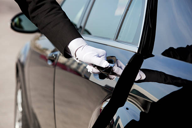 Chauffeur opening / closing luxury car door The white gloved hand of a uniformed chauffeur / doorman opening / closing a luxury car door. service occupation stock pictures, royalty-free photos & images