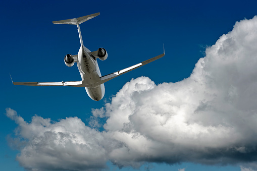 corporate jet airplane flying in cloudy sky