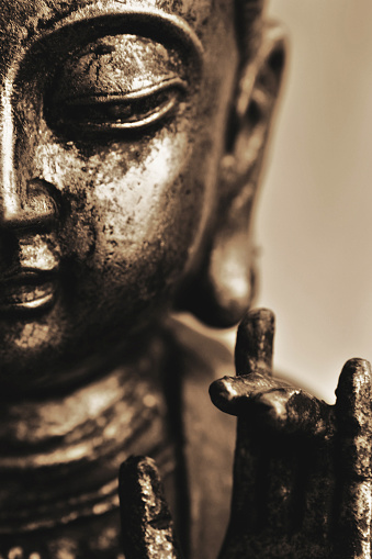 smiling buddha in close-up with karana hand gesture, vertical frame