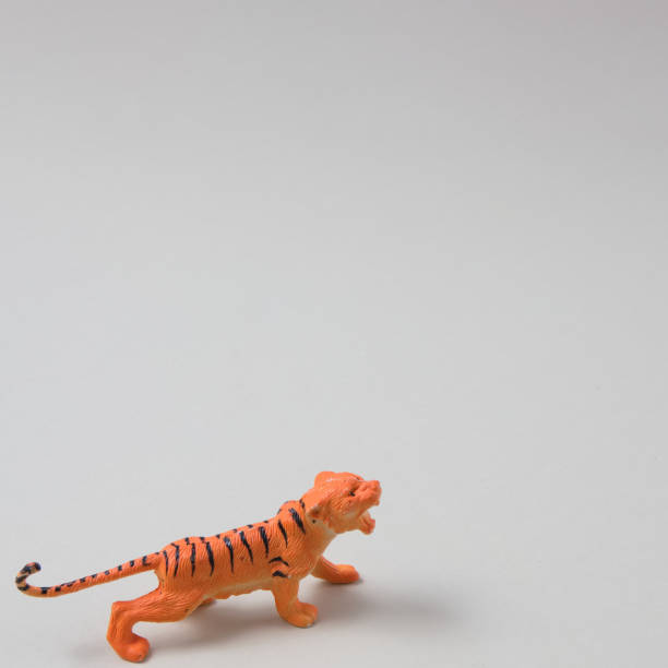 istock A tiger sneaking on a beige background. Animal scene. 1368995665