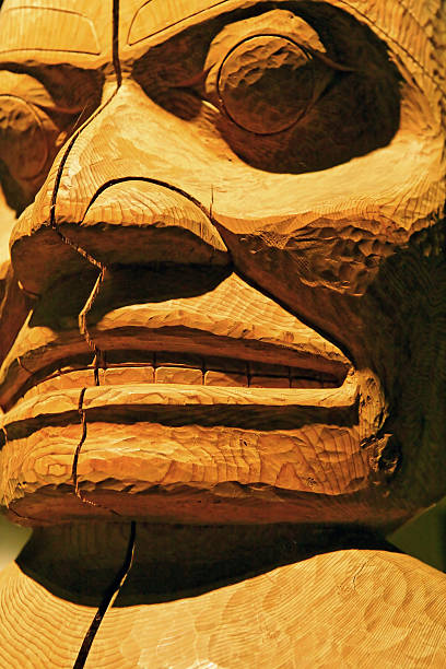 totem pole close-up old cedar totem pole in close-up, vertical frame pacific northwest totem poles stock pictures, royalty-free photos & images