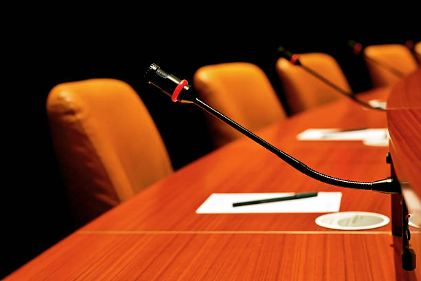 round conference table round conference table in close-up with microphones round wooden chair stock pictures, royalty-free photos & images