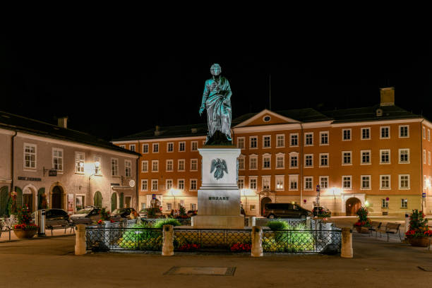 Salzburg, Austria; July 10, 2021 - In the centre of the Mozartplatz is the Mozart statue by Ludwig Schwanthaler at night. The Mozartplatz is located in the centre of Salzburg's Old Town