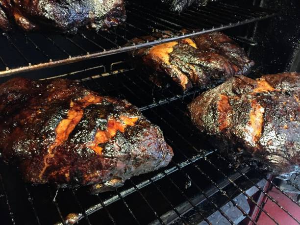 Smoked Pork Butts Slowly smoked over hard wood until a dark crust is evenly all over the pork butts bbq smoker stock pictures, royalty-free photos & images