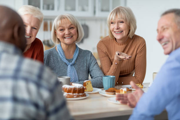 istock Multiracial group of positive elderly people drinking tea with cake 1368998401