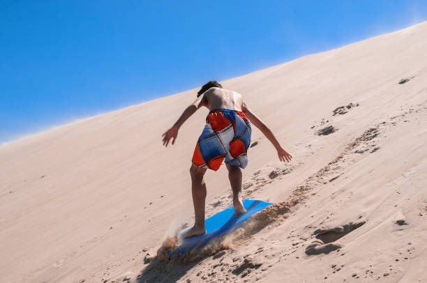 istock Caucasian young man sliding on a board in the sand 1369000133