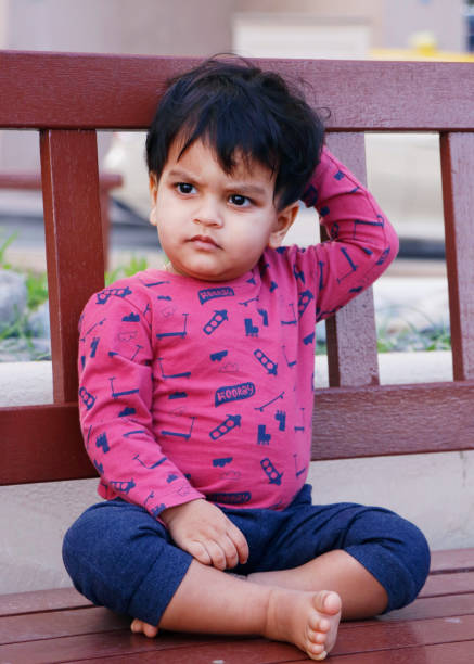 istock adorable young handsome indian baby sitting on a bench 1369000164