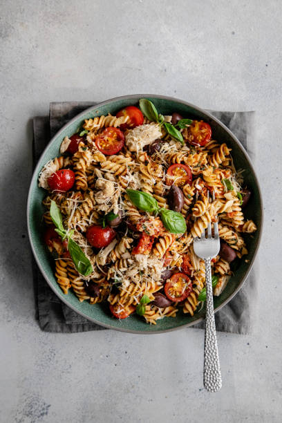 istock Pasta fusilli with vegetables in a grey plate on a stone table 1369000432