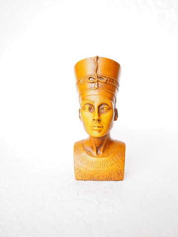 Bust or statue of the ancient Egyptian queen Nefertiti made of brown stone on a white background. The symbol of eternal female beauty. Isolate. Front view of the face.