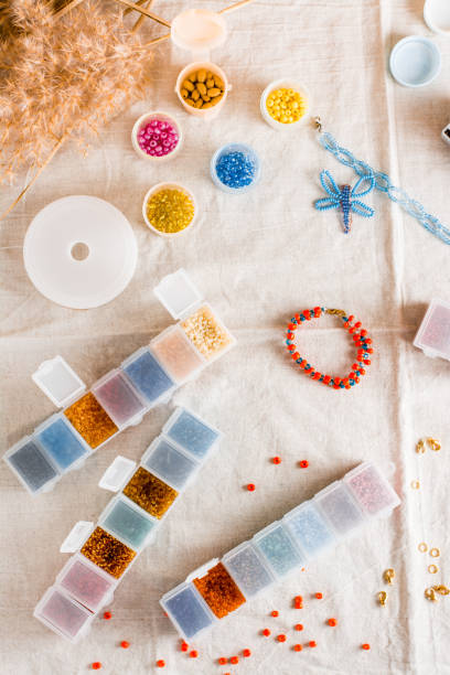 istock Items for beading - boxes with beads, thread and scissors on the table. Creative leisure, home teaching crafts for children. Top  and vertical view. 1369002722
