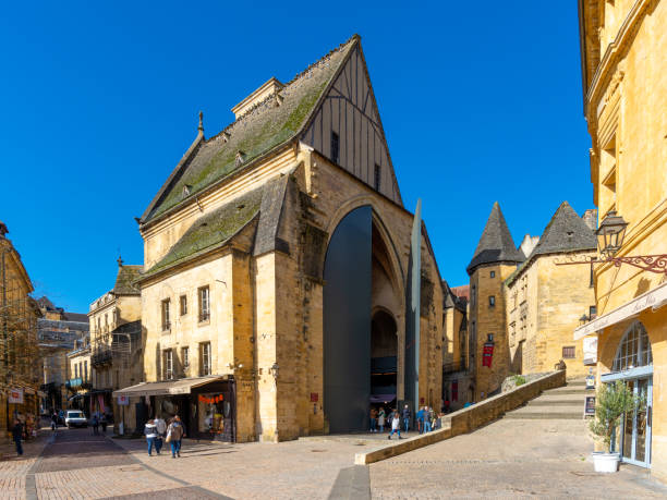 The market hall of a a beautiful french yellow stone town of Perigord Sarlat-la-Caneda, France - November 1, 2021: The market hall of a a beautiful french yellow stone town located in Perigord, France, taken on a sunny autumn afternoon with some people seen from afar. sarlat la caneda stock pictures, royalty-free photos & images