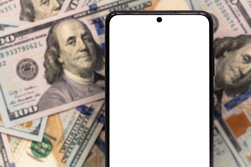 white smartphone screen  on US dollar banknotes background for design purpose