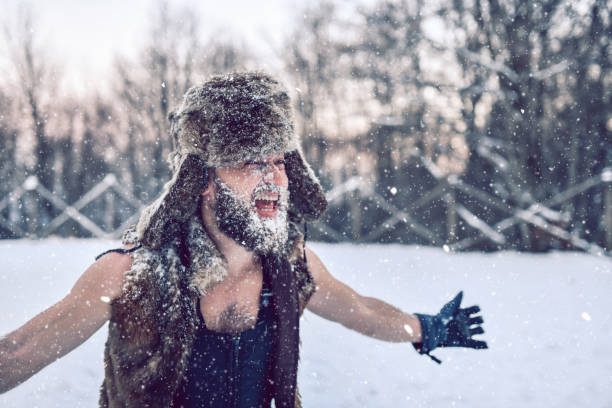 istock Smiling Bearded Male Exploring Wilderness By Putting Snow On Face While Wearing Fur 1369006677